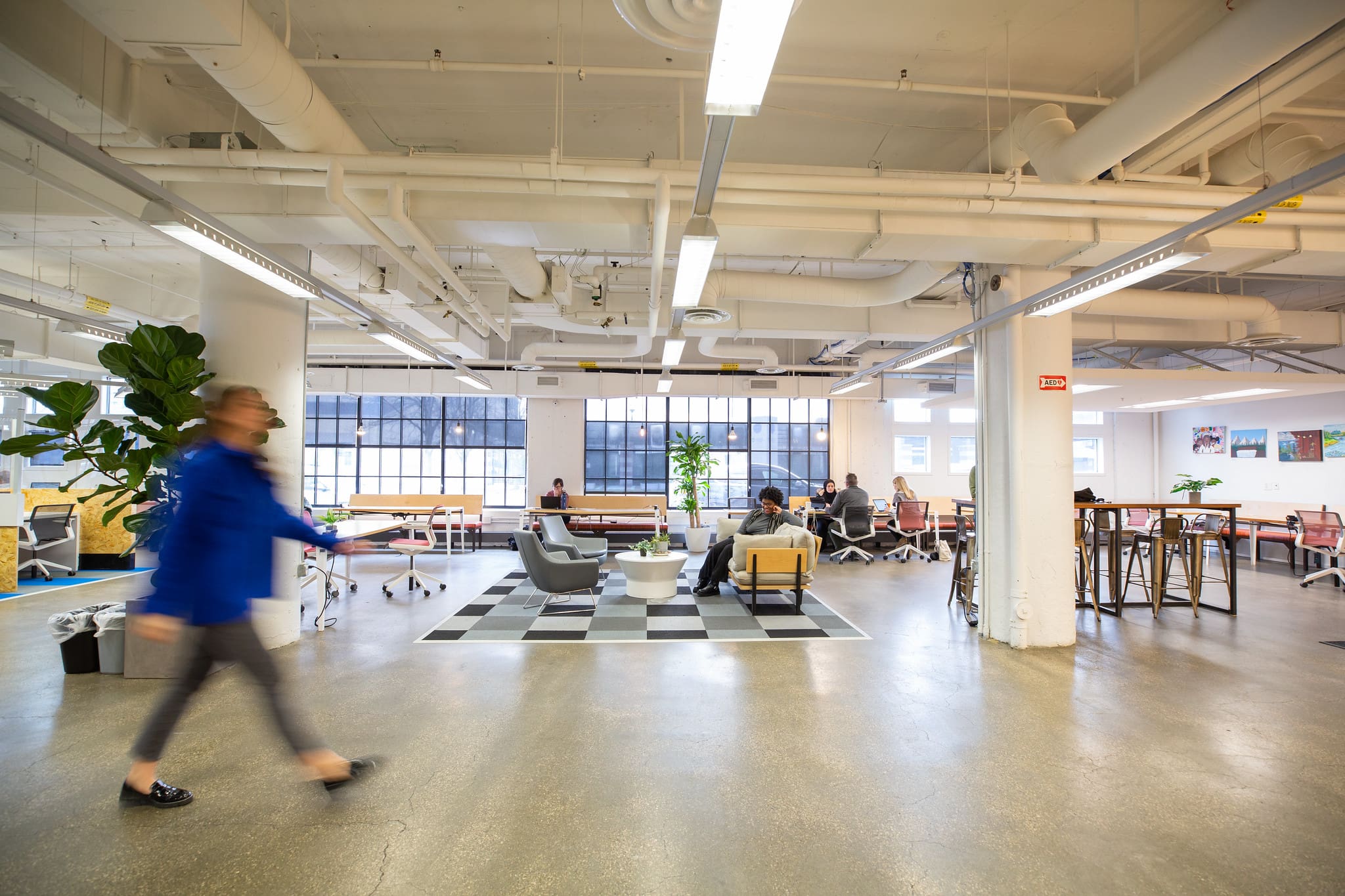 A bustling hallway and workspace with people moving briskly at TechTown Detroit.