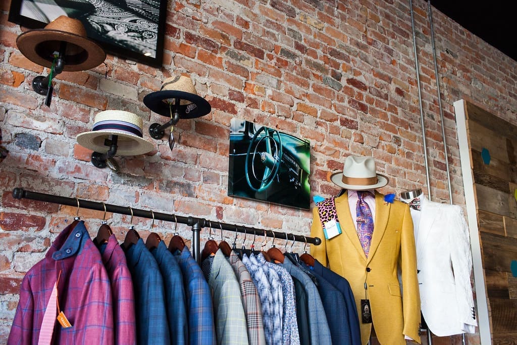 A merchandising display at Bleu Bowtique, featuring men's suit jackets, hat's bowties and other accessories