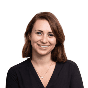 A woman smiling for a headshot, wearing a black top and a necklace