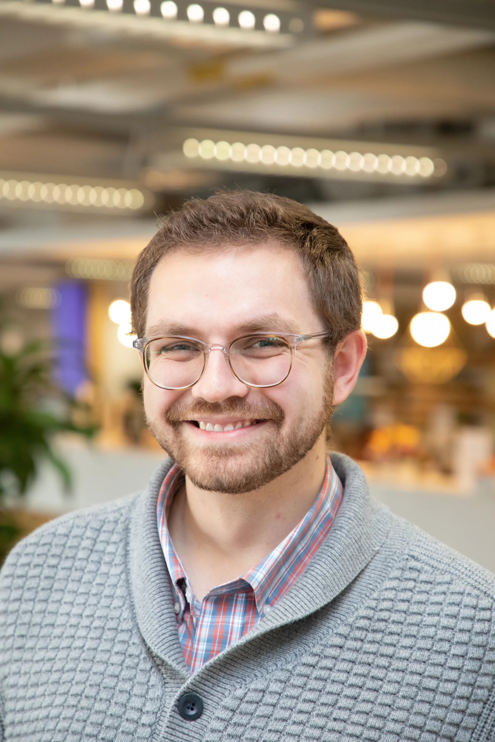 David Behrens wearing light grey sweater and wearing glasses.