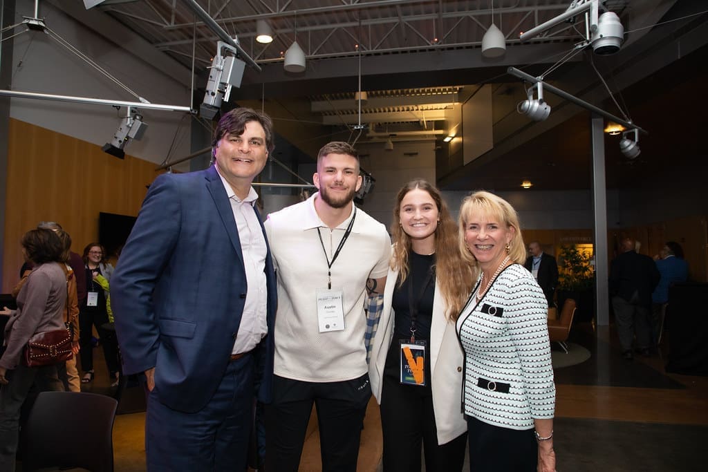 Four people smile for a photograph