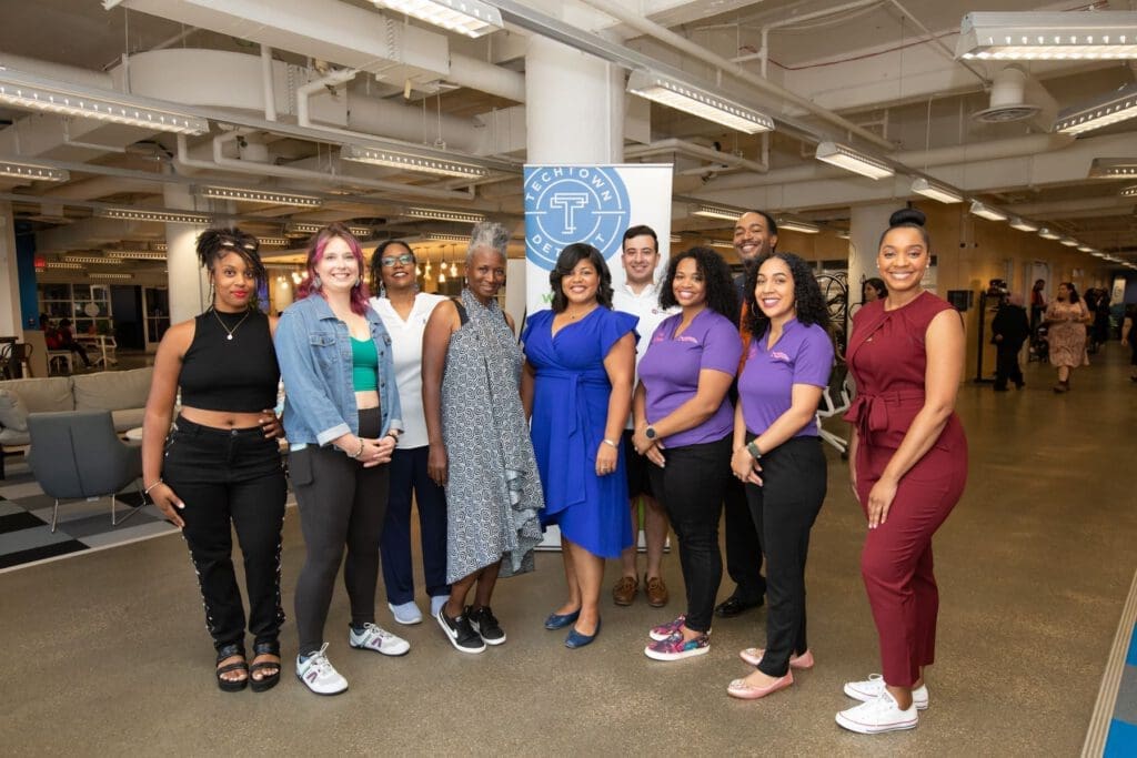 A group of 10 people pose and smile for a photograph