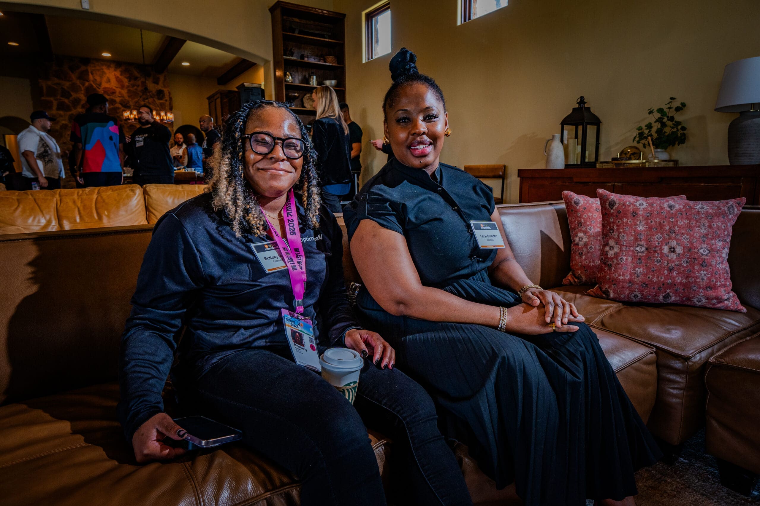 Two people sitting on a couch smile for a photo